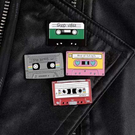 Example of all 4 cassette tape shaped enamel pins on a leather jacket.