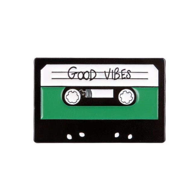 Enamel Pin shaped like a cassette tape that has "good vibes" written on the label.